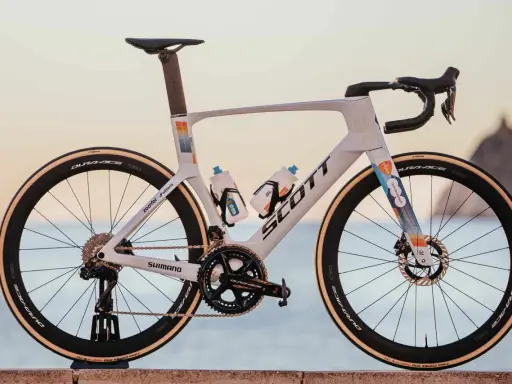 Biały rower szosowy Scott z kolorowymi akcentami, na jakich rowerach jeżdżą kolarze. Wyposażony w Dura-Ace, Shimano i Vittoria.