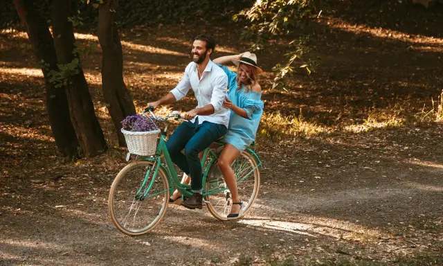 Szczęśliwa para na rowerze w parku. Rama 17 cali na jaki wzrost? Idealna na romantyczny spacer.