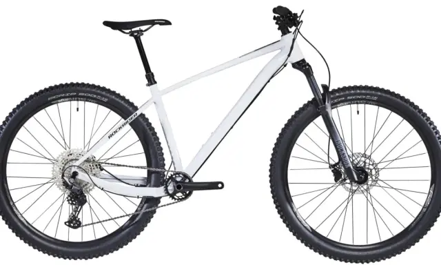 Biały rower hardtail z szerokimi oponami i amortyzatorem RockShox, gotowy na terenowe wyzwania.