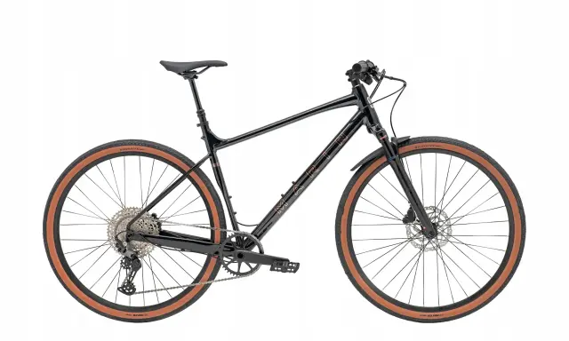 Czarny rower gravel z prostą kierownicą, brązowymi oponami i błotnikami. Idealny na przygody po szutrowych drogach.