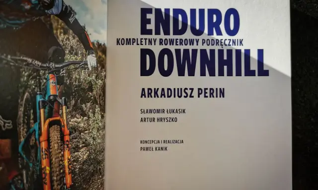 Książka "Enduro Kompletny Rowerowy Podręcznik Downhill" z rowerzystą w akcji. Dowiedz się, co to downhill!