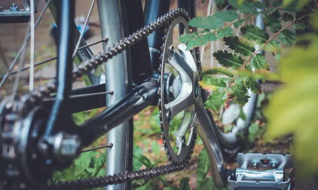 Zbliżenie na rowerowy napęd: korba, zębatka i łańcuch. Dowiedz się, jak dobrać długość łańcucha rowerowego, by jazda była płynna.