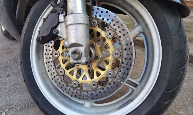 Motocykl z tarczami hamulcowymi i zaciskiem. Ostre koło hamowanie zapewnia bezpieczeństwo na drodze.
