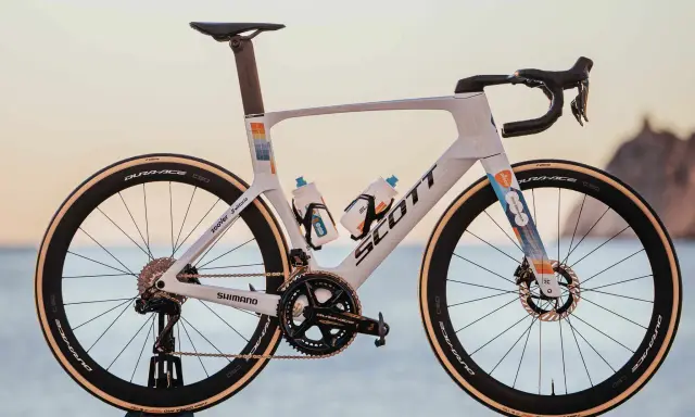 Biały rower szosowy Scott z kolorowymi akcentami, na jakich rowerach jeżdżą kolarze. Wyposażony w Dura-Ace, Shimano i Vittoria.