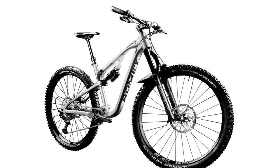 Srebrny rower górski full-suspension, model Dagger 2.0, z oponami Michelin Wild Enduro. Idealny do jazdy po trudnym terenie, czyli właśnie mtb co to.