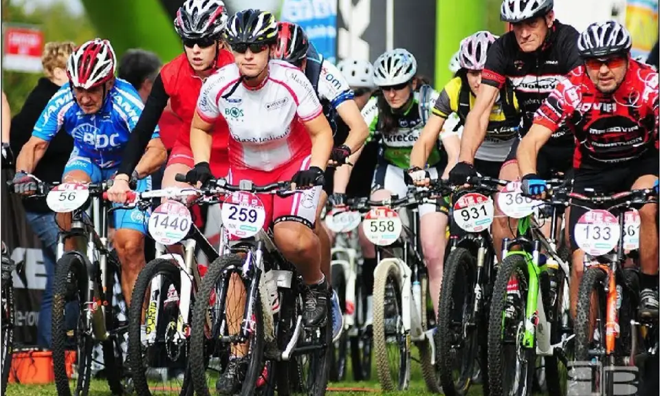 Zawodnicy w kaskach i strojach kolarskich startują w wyścigu mtb bike maraton.
