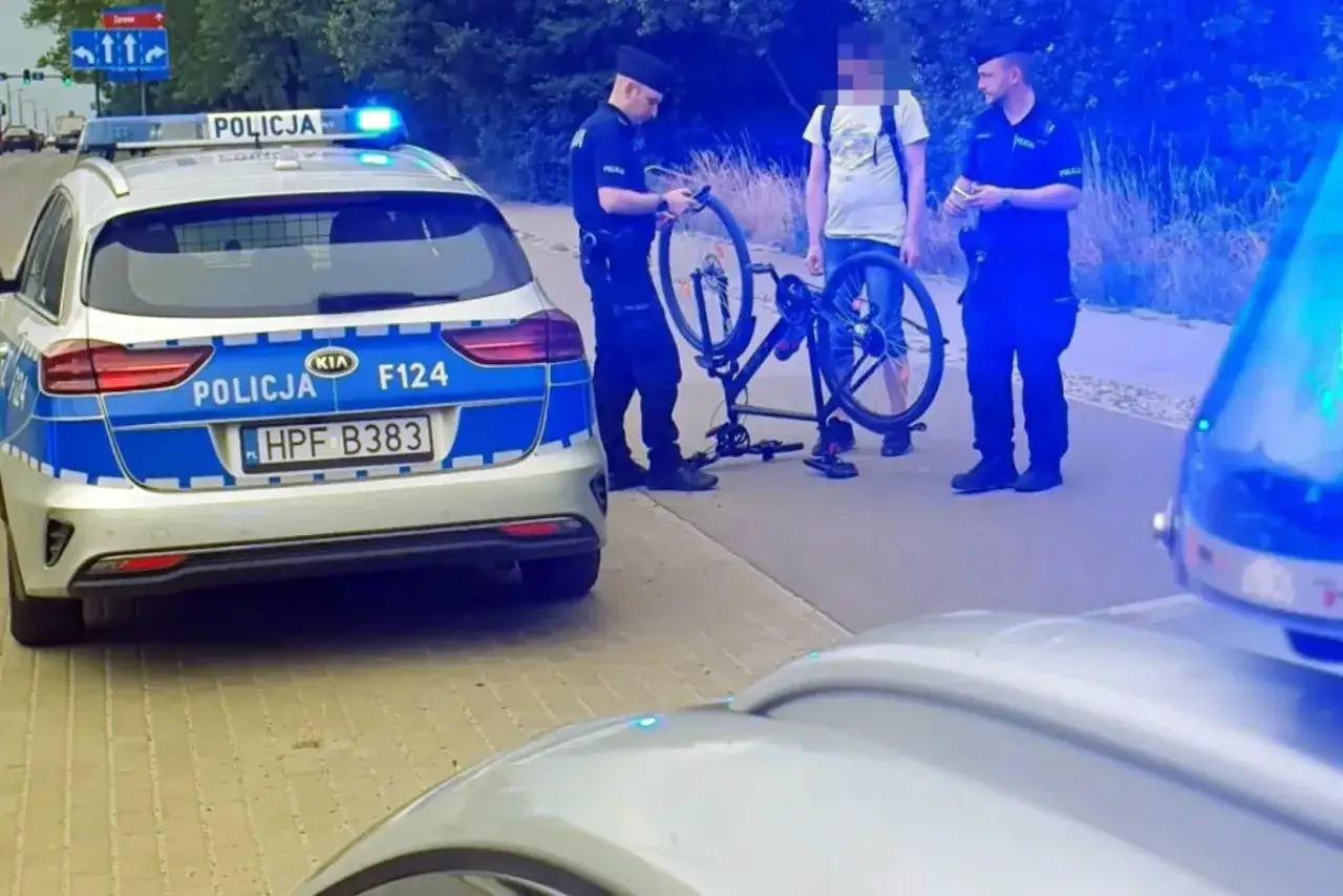 Policjanci przy radiowozie rozmawiają z rowerzystą. Czy można stracić prawo jazdy na rowerze? To pytanie zadaje sobie wielu.
