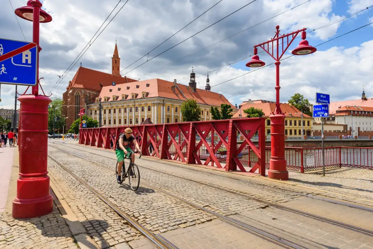 Mężczyzna na rowerze przemierza most we Wrocławiu. To świetny spos&oacute;b, by poczuć miasto i zobaczyć, dlaczego warto jeździć rowerem.