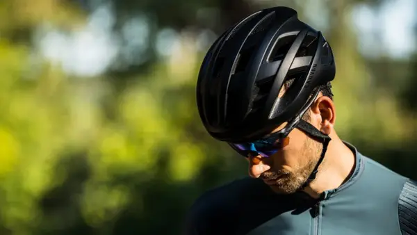 Mężczyzna w czarnym kasku rowerowym Canyon i okularach przeciwsłonecznych, gotowy na jazdę. Jaki kask na rower wybrać? Ten wygląda świetnie!